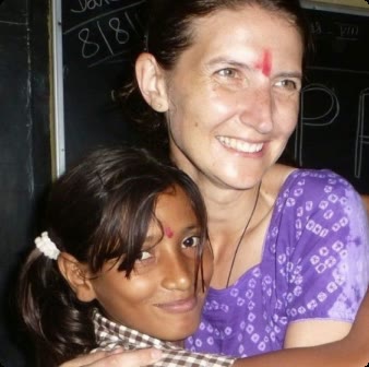 Une marraine et sa filleule, souriantes, devant un tableau d'école